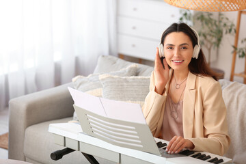 Young female musician playing synthesizer at home