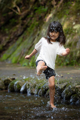 渓流で水遊びする小さな女の子