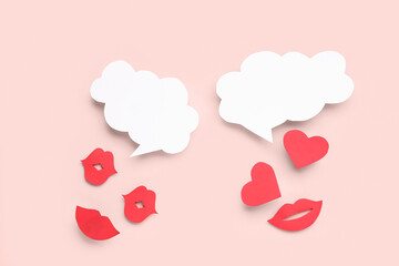 Paper lips and and hearts with blank speech bubbles on pink background
