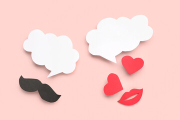 Paper mustache, lips and hearts with blank speech bubbles on pink background