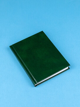 Design concept - top view of  green notepad  on wooden table