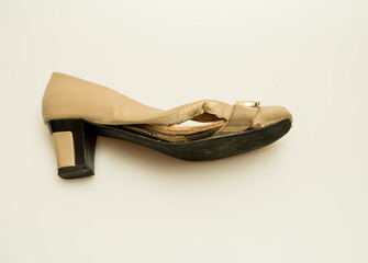 Humidity and water damaged women's shoe isolated against a white background.  
