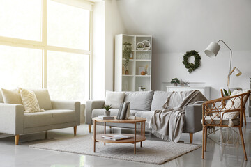 Interior of living room with sofas, armchair and stylish holder for books on coffee table