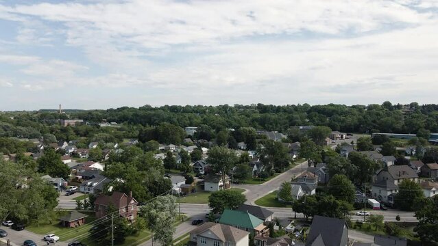 Aerial dolly push in above calm suburban neighborhood in Canada, lush green trees