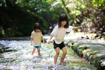 渓流で水遊びする姉妹