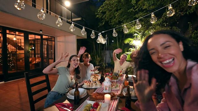 Cheerful black woman taking video call and celebrating outdoors party atmosphere with family at garden within the house. Big family multi-ethnic celebrating outdoors party at garden within the house.