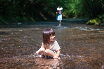 渓流で水遊びする小さな女の子
