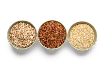 Three bowls of buckwheat, oatmeal and millet on white background