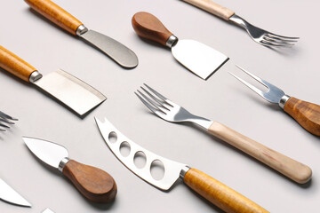 Set of knives and forks on grey background