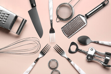 Set of different kitchen utensils on beige background