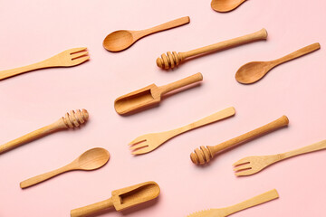 Wooden kitchen utensils on pink background