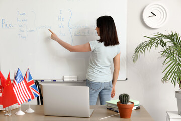 Female English teacher giving online grammar lesson in classroom - obrazy, fototapety, plakaty