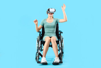 Young woman in wheelchair using VR glasses on blue background