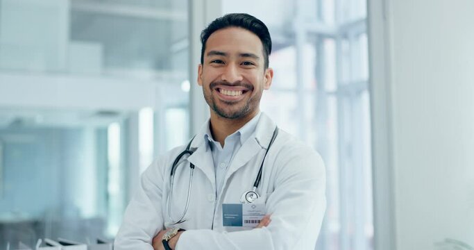 Man, face and doctor with arms crossed in hospital for healthcare services, surgery and clinic consulting. Portrait of happy asian surgeon, expert therapist or medical professional working with trust