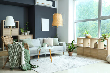 Interior of modern living room with plants, sofa and armchair