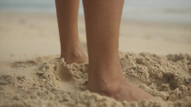 Cinematic slow motion shot of female feet moving through fine sand on the beach in Goa, India, Slomo