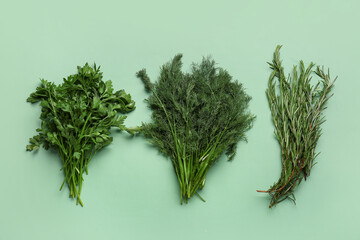 Bunches of fresh parsley, dill and rosemary on color background
