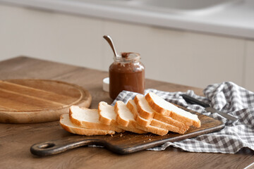 Board with bread slices on dining table, closeup