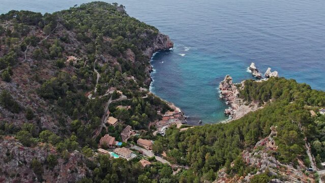 Mountain Village Of Deia And Cala Deia Beach In Mallorca, Spain. aerial tilt-down