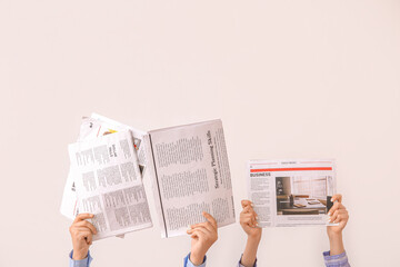 Naklejka premium Female hands with different newspapers on light background