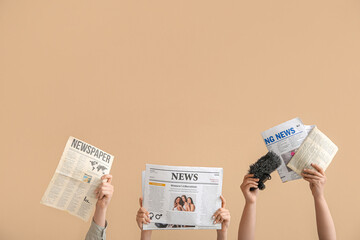 Female hands with different newspapers and microphone on color background