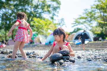 自然の河川プールで水遊びをする姉妹
