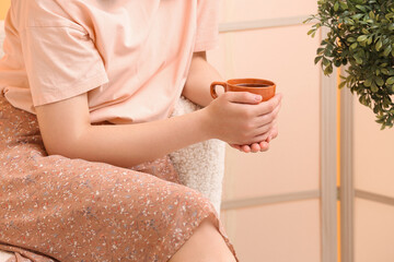 Obraz na płótnie Canvas Woman holding cup of tasty coffee at home, closeup