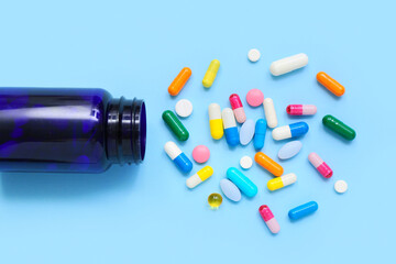 Composition with colorful pills and bottle on color background, closeup