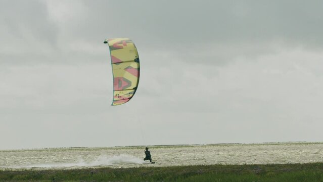 Epic cinematic slow-motion shot of a kite surfing surfing at the local beach of Sankt Peter Ording, Germany.