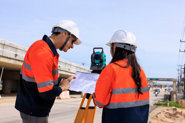 Engineer use theodolite equipment and looking blueprints construction project for route surveying...