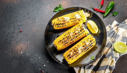 Summer food. Ideas for barbecue and grill parties. Grilled corn grilled on fire. With a sprinkle of...