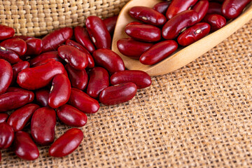Closeup red beans or kidney bean in wooden bowl isolated on wood table background.