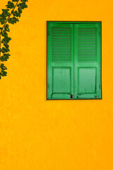 Vintage Closed Green Window On Yellow Concrete Wall, Old Grren Wood Window Closed On Yellow Wall 