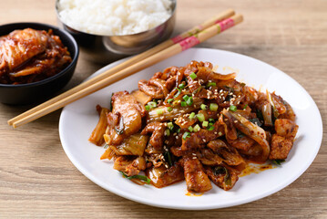 Korean stir fried kimchi cabbage with pork eating with kimchi and cooked rice on wooden table