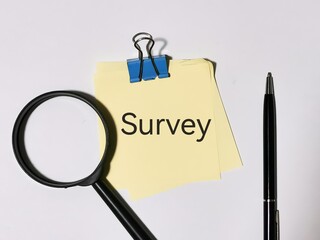 Text survey written on notepad with a pen and magnifier.