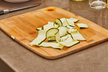 Sliced zucchini in the home kitchen on wooden board