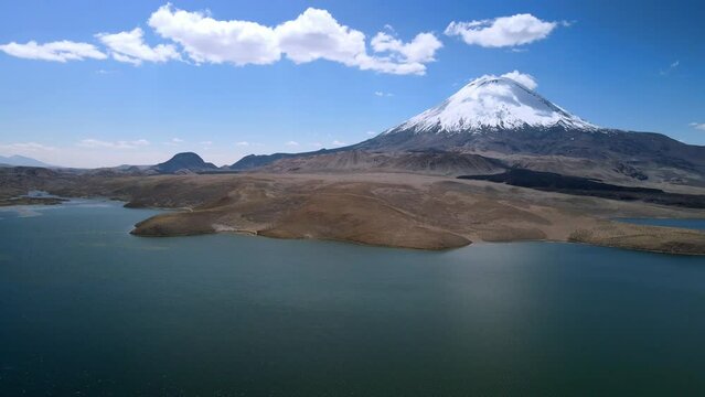 Aerial view over of the scenic Chungara Lake and Parinacota volcano, Chile - dolly, drone shot