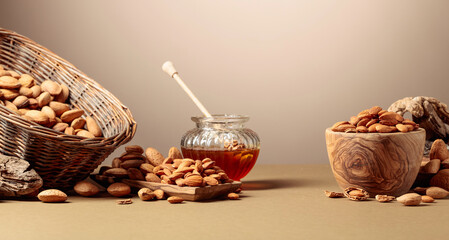 Almond nuts in wooden dishes and honey in a glass jar.