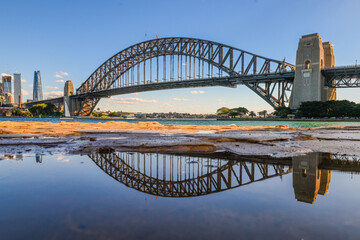 The Sydney Harbour Bridge can be seen in a reflection in North Sydney on a Sunny winter day. 