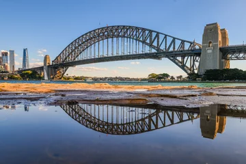 Photo sur Plexiglas Sydney Harbour Bridge The Sydney Harbour Bridge can be seen in a reflection in North Sydney on a Sunny winter day. 