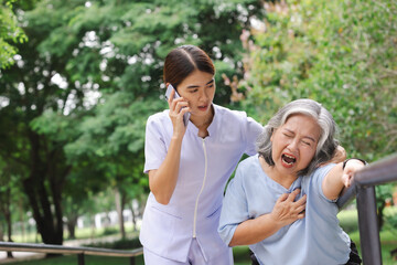 Fototapeta premium Senior adult women suffering heart attack and worried nurse making emergency call. 