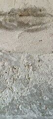 Abstract gray background. Gray old concrete wall with traces of plaster and whitewash marks. Uneven rough surface. Cement background Free focus. Elongated Vertical Format