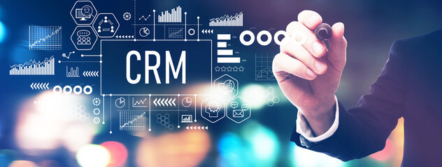 CRM - Customer Relationship Management theme with a businessman in a blurred city lights at night