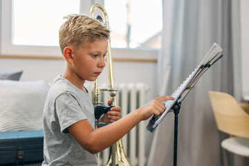 Young Caucasian boy is reading notes to get familiar with the composition.