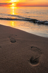 Footprints on the beach at sunset
