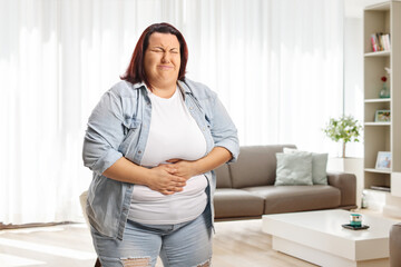 Young overweight woman with abdominal pain at home
