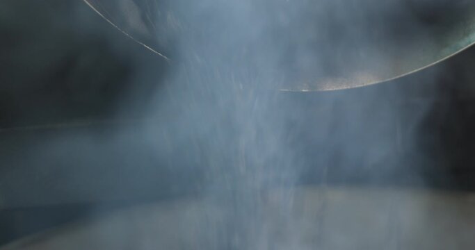 Coffee roaster machine at coffee roasting process. Dark Mixing coffee beans. Roasted spinning cooler professional machines and fresh brown coffee beans movement. close up 4k video