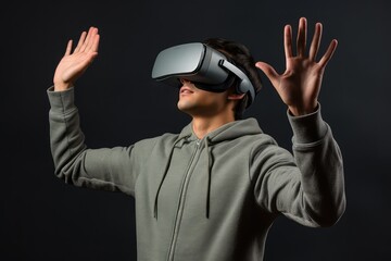 Young man using virtual reality headset, plain grey background