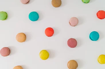 Raamstickers Colorful pattern made of various macarons on white background. Creative minimal sweet food concept. Trendy macaron cookies pattern background. Yummy flat lay idea. © Jakov