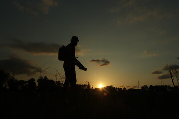 Young man standing at sunset, concept of wanderlust